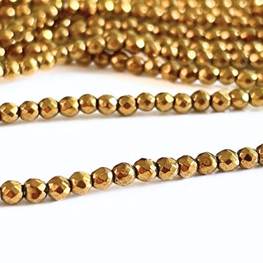 Guldfarvede facetslebne Hæmatit perler 2 mm – ca. 195 stk. på streng