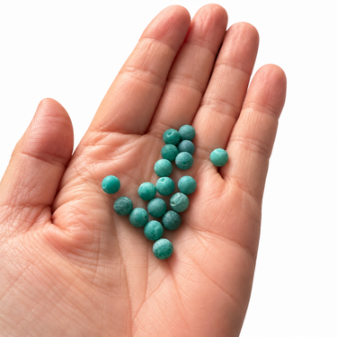 6 mm matte grønne agatperler vist i hånd